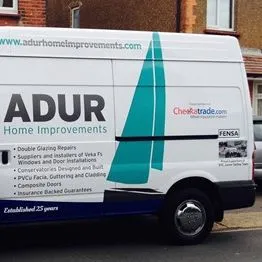 The Adur Home Improvements van, white with the teal sail logo, parked on a street